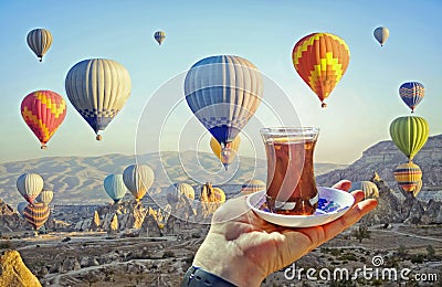 Morning cup of tea with view of colorful hot air balloons Stock Photo