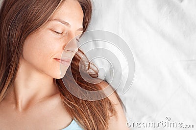 Morning at Home. Woman lying on bed sleeping smiling happy top view close-up Stock Photo