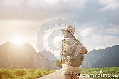 Morning light and young woman travel backpacking on road and forest background Relax time on holiday concept travel Stock Photo