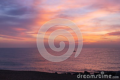 Morning pink sky reflected in the sea. A small lonely fisherman boat silhouette sailing during the sunrise. Soft color Stock Photo