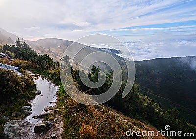 Morning reflection in i puddle on a mountain ridge walking path in a slope above the clouds, Low Tatras, Slovakia Stock Photo
