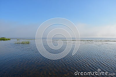 Morning river fog creeps over the water beautiful view blue sky clouds reflected in the water Stock Photo