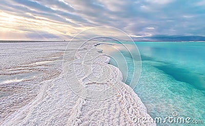 Morning scenery - white salt crystals beach, clear water near, typical landscape at Dead Sea shore, Israel Stock Photo