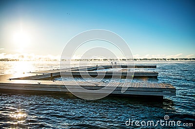 Morning Sunrise on a dock with Muskoka Chairs Stock Photo