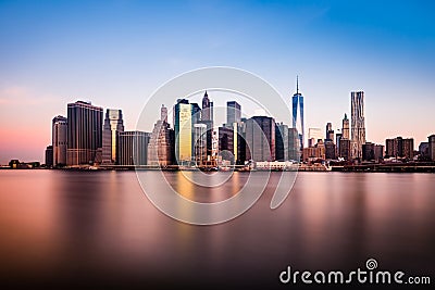 Morning view of lower Manhattan silhouette reflexing in the clear waters of East River Stock Photo