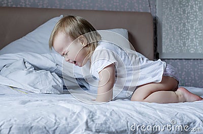 Baby screaming and crying in bed. Tantrums and whims of children. Stock Photo