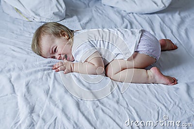 Baby screaming and crying in bed. Tantrums and whims of children. Stock Photo