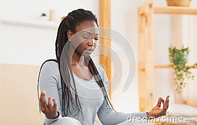 Relaxed Afro Woman Meditating Sitting In Lotus Position At Home Stock Photo