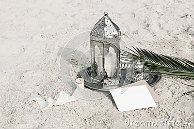 Moroccan, Arabic lantern with cup of tea, coffee and date palm leaf on silver tray in sand. Muslim holiday Ramadan Stock Photo