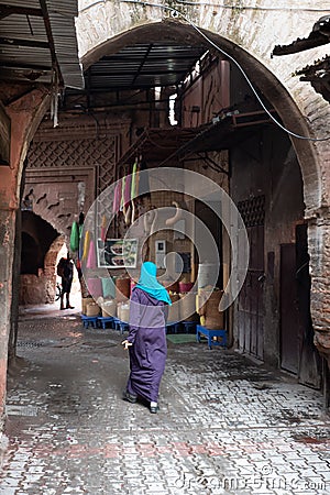 Moroccan woman shopping in old street. Morocco, Marrakech. Copy-space Editorial Stock Photo