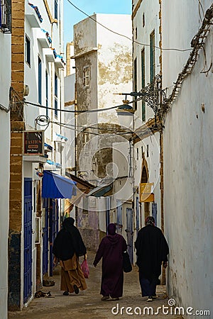 Morocco. Essaouira. Three women dressed in djellaba walk down a street Editorial Stock Photo