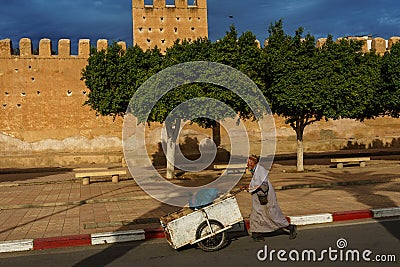 Morocco. Taroudant. A man pushing a cart in front of the city walls Editorial Stock Photo