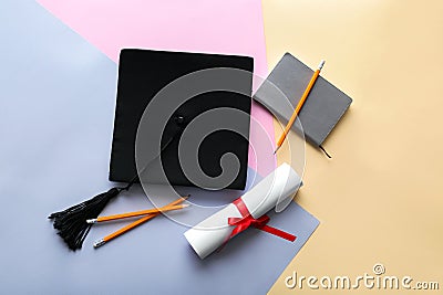 Mortar board with diploma and stationery on color background. Concept of high school graduation Stock Photo
