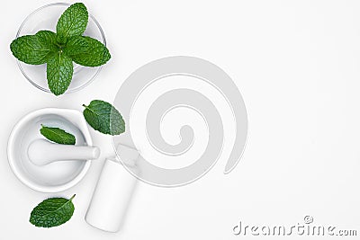 Mortar Grinder drugs, glass bowl and bottle with fresh herbs - Mints isolated on white background. For copy space Stock Photo