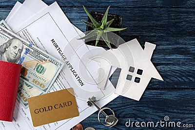 Mortgage application. Key with house keychain and blank and money on a blue wooden table. concept of buying a home. top view Stock Photo