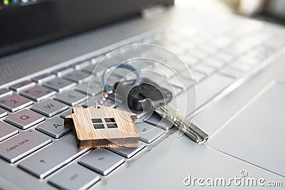 Mortgage concept with keys and house-shaped key ring on laptop keyboard. Find dream house in internet concept. Online assistance Stock Photo