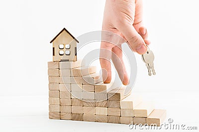 Mortgage concept with male hand with keys going up to wooden stairs. Purposefulness of man in career stairs Stock Photo