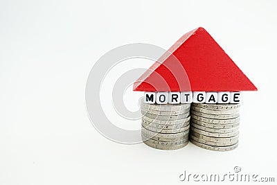 Mortgage or housing loan concept with small house made from money and wooden piece, isolated on white background Stock Photo