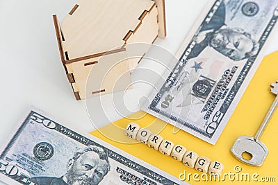 mortgage, loan and home purchase. Model of house, dollar bills, key on white and yellow isolated background. Free space for text, Stock Photo