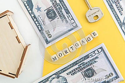 mortgage, loan and home purchase. Model of house, dollar bills, key on white and yellow isolated background. Free space for text, Stock Photo