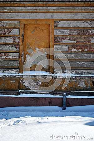 Mortgaged window of the old brick building with cracked plaster, winter snowy street Stock Photo