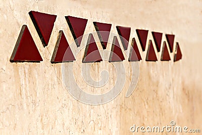 Mosaics in a line of triangles on wall in perspective Stock Photo