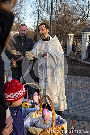 MOSCOW - APRIL 11, 2015: Orthodox priest sprinkles Easter eggs a Editorial Stock Photo