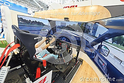 MOSCOW, AUG. 22, 2017: View on exhibition stand with 3d car driving simulator with wide led screens, electronic hydraulic tilting Editorial Stock Photo