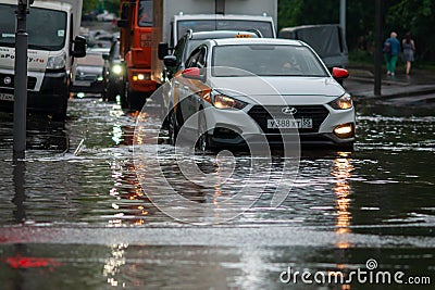 Cars in city traffic after heavy rain driving through flood Editorial Stock Photo