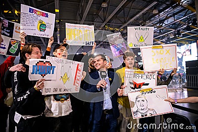 MOSCOW - DECEMBER 23 2019: esports professional gaming event. Newsman with microphone interviewing gaming fans which are Editorial Stock Photo