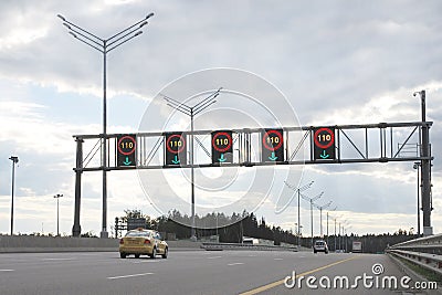 Information board with speed limit signs up to 110 km per hour above expressway lanes. Cars driving on toll road Editorial Stock Photo