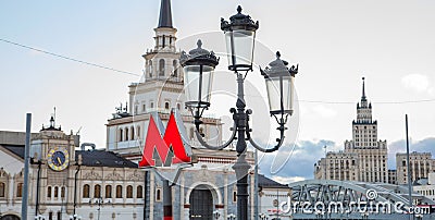 Moscow metro sign and Stalinist architecture on background. Selective focus on Metro sign Editorial Stock Photo
