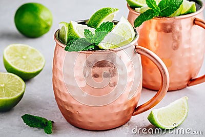 Moscow mule ice cold cocktail in copper cup with lime and and mint on gray stone background Stock Photo