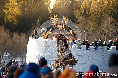 Straw scarecrow and ice fort full of people, Bakshevskaya Shrovetide maslenitsa celebration Editorial Stock Photo