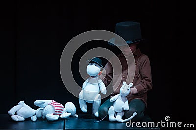 Moscow region / Russia - 01 06 2019: Theatre performance with Moomins trolls. Young boy plays with Moomin Troll dolls. Actor Editorial Stock Photo