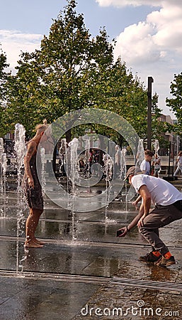 Moscow, RF Sept, 01 2019: Street photo. A couple of people having fun in the city fountain. A woman frolics in the jets of water, Editorial Stock Photo