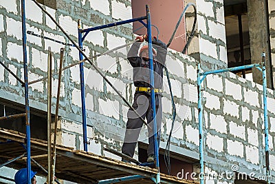 MOSCOW, RUSSIA,APRIL,29.2019:Working men on the scaffolding.Construction of a new shopping center Editorial Stock Photo