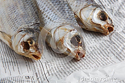 MOSCOW / RUSSIA - 13/05/2020 close up top view shot of three dried salted vobla Caspian Roach fish lying on a Russian newspaper Editorial Stock Photo