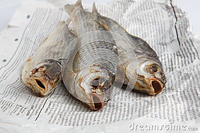 MOSCOW / RUSSIA - 13/05/2020 close up top view shot of three dried salted vobla Caspian Roach fish lying on a Russian newspaper Editorial Stock Photo