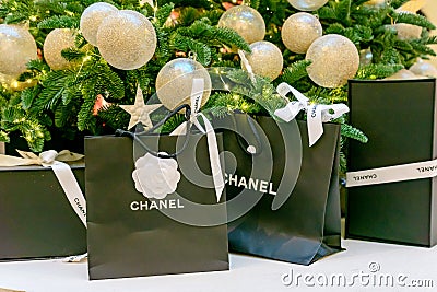 Moscow, Russia - December 15, 2021 - Chanel logo on black paper bags with presents under christmas tree. Luxuary brand of clothes Editorial Stock Photo