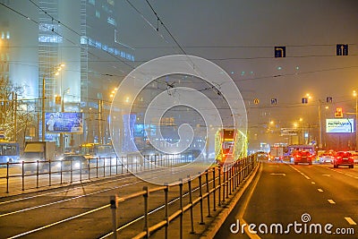 Moscow, Russia. December 26, 2019 A tram lit by a network of LEDs travels on rails in a foggy night. Environmentally friendly Editorial Stock Photo