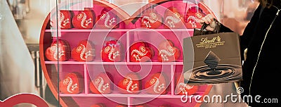 Moscow, Russia, February 2021: Banner with Lindt branded packages on the background of a decorated shop window in hearts Editorial Stock Photo