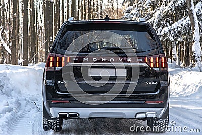 Moscow, Russia - February 15, 2021: Kia Mohave 2021 black SUV parked in the forest in winter. On the road. Alone in the woods back Editorial Stock Photo