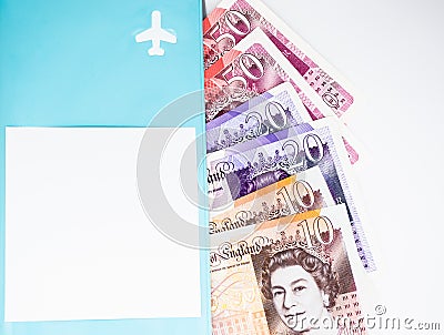 Moscow, Russia, February 2020: A pile of ten, twenty and fifty pound notes is visible from a blue folder with an airplane and a Editorial Stock Photo