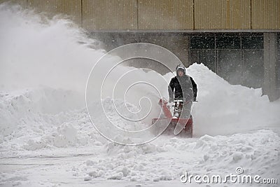 Moscow, Russia, February 13, 2021: Snow removal with snow blower during snowfall, Olympic Village, Michurinsky prospect Editorial Stock Photo