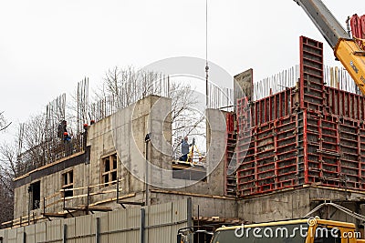 Moscow, Russia - January 7, 2020: Construction of an office building. Construction workers in overalls align the guides for Editorial Stock Photo