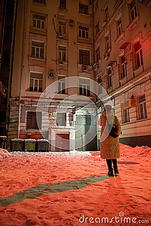 Girl stands in the middle of an old Moscow courtyard on a cold winter night Editorial Stock Photo
