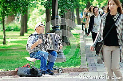 A street musician plays a accordion in the Moscow park. Editorial Stock Photo
