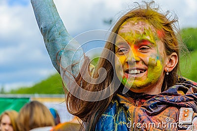 Moscow, Russia - June 3, 2017: Little girl with joyful smile and multi-colored face on summer holiday Holi Editorial Stock Photo