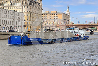 Moscow, Russia - June 21, 2018: Loaded barge floating against Moskva river embankment on a sunny summer day Editorial Stock Photo